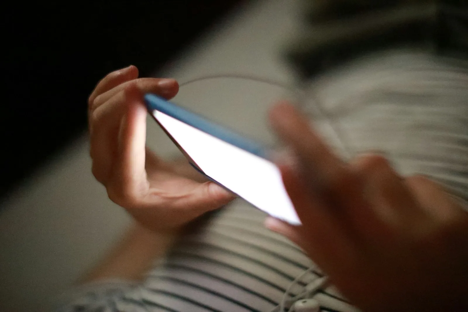 Manos sosteniendo un celular iluminado