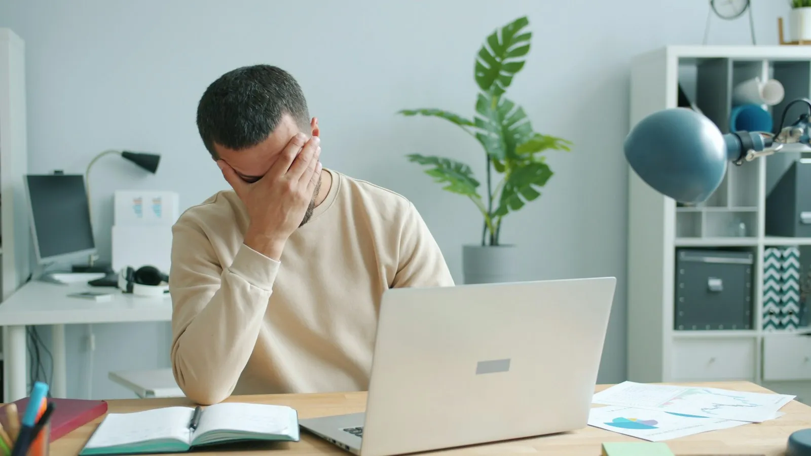 Hombre agotado frente a su laptop