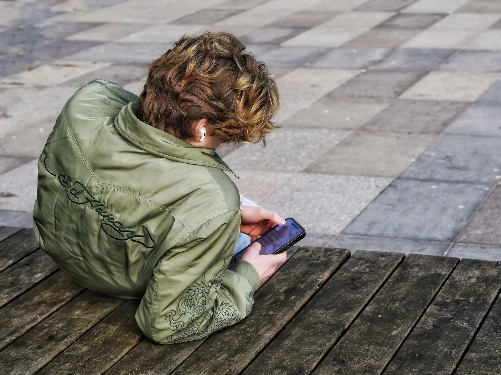 Niño sentado mirando su celular
