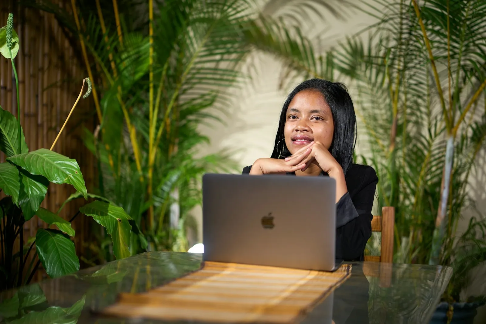 Mujer sonriendo en su espacio de trabajo con plantas