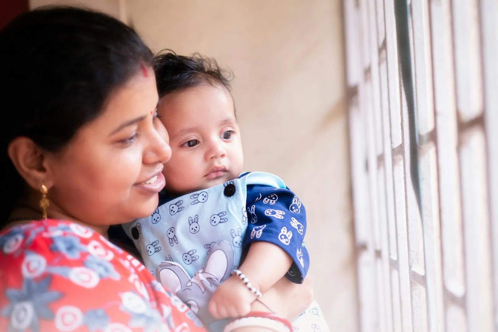 Madre sonriendo con su bebé en brazos