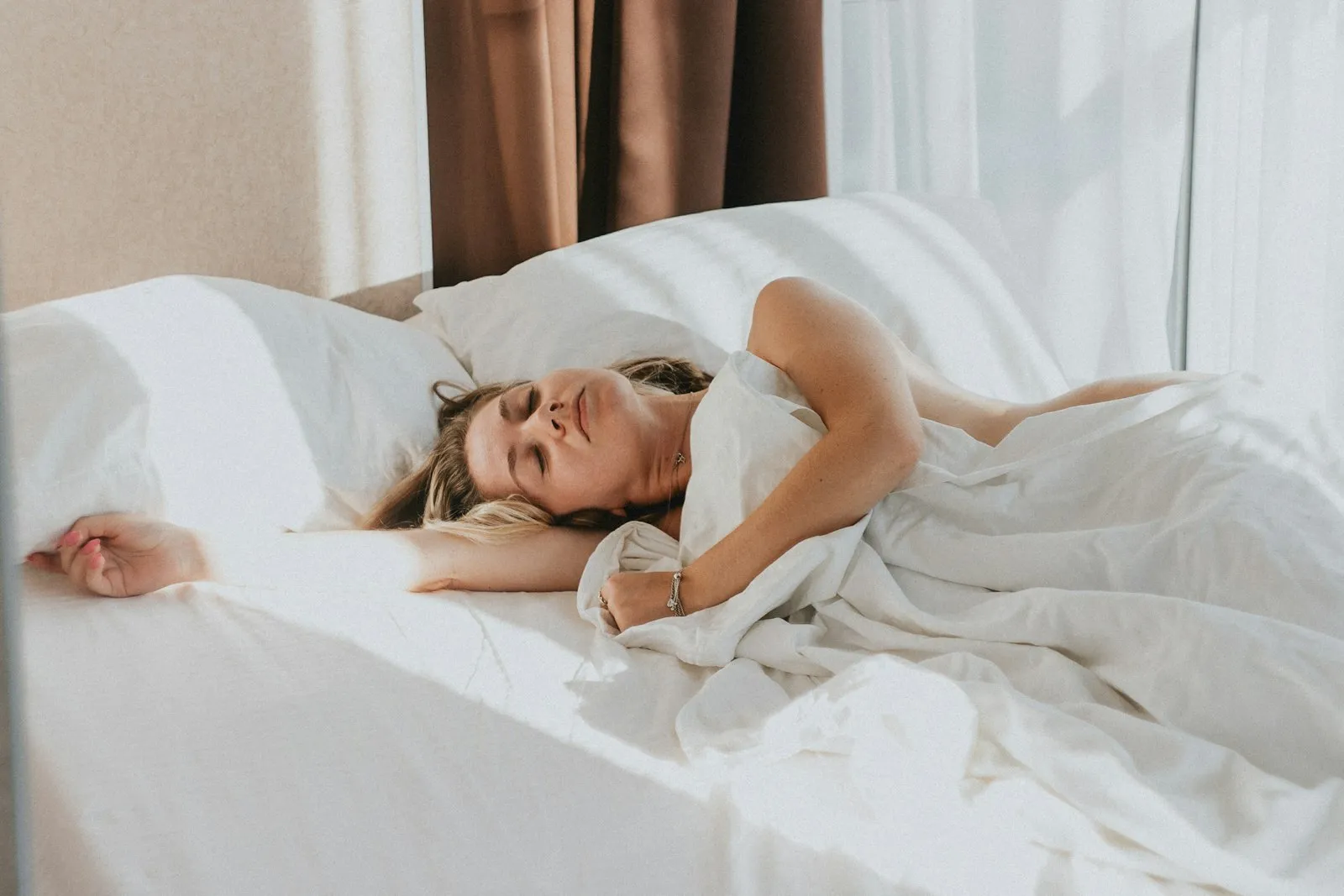Mujer durmiendo en una cama blanca